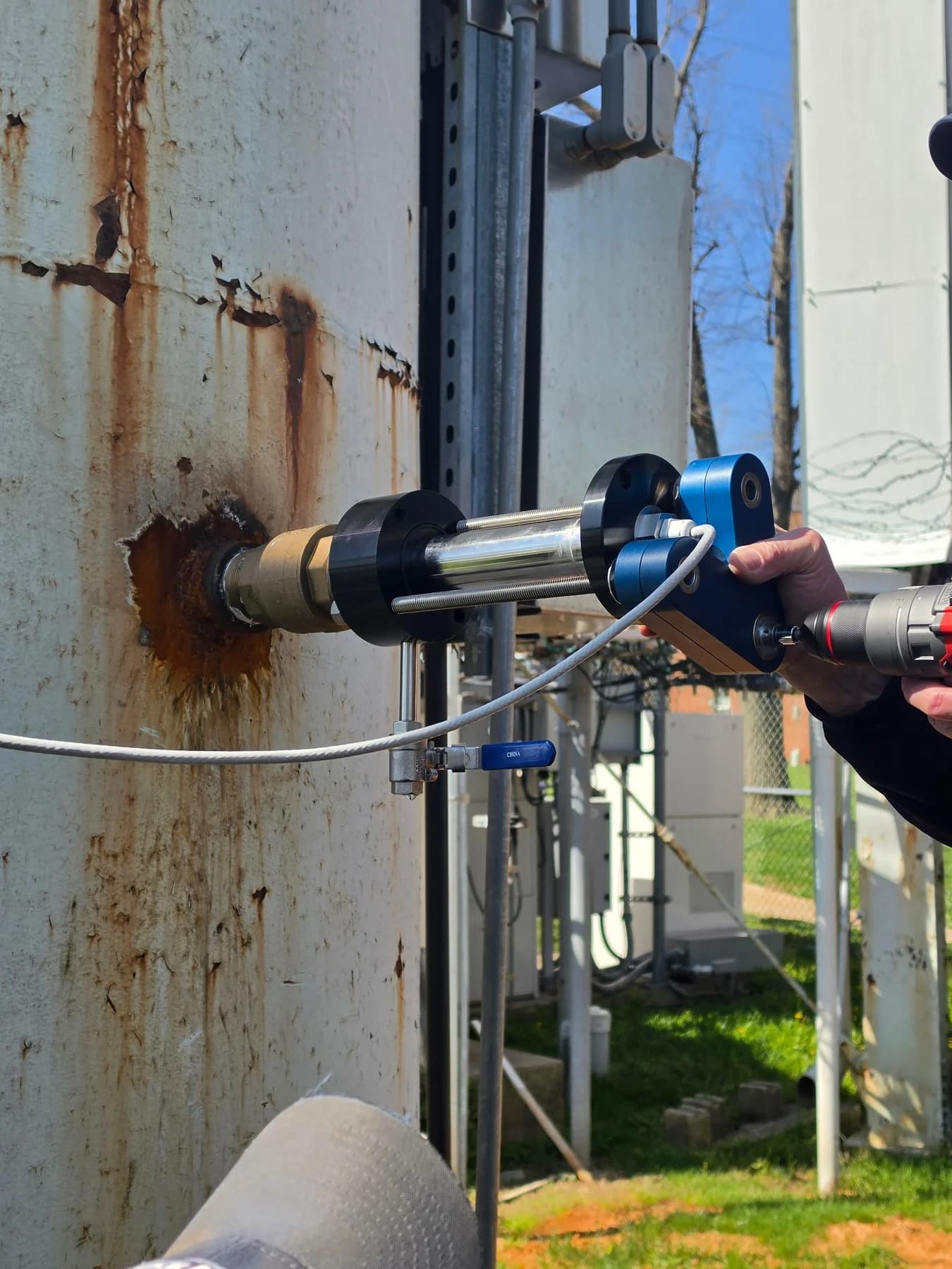 Technician using a remover assembly at a tank-wall connection